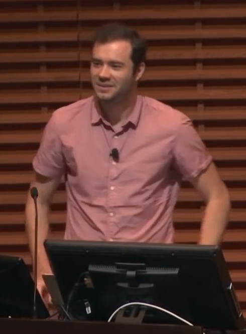 Andrej Karpathy debout derrière un pupitre, en conférence, décembre 2019